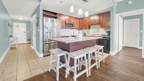 A modern kitchen with wooden cabinets, stainless steel appliances, and a central island with bar stools. - BEST 🌴Stocked Family❤️ Condo! 🌴16th Floor AMAZING GULF Views ❤️Easy Walk to Beach! (Panama City Beach)