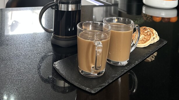 A kitchen counter with a coffee maker, two glasses of coffee, and a bowl of fruit. - Beautiful House in picturesque Morfa Nefyn. Sleeps 12 and 2 mins from the beach (Morfa Nefyn)