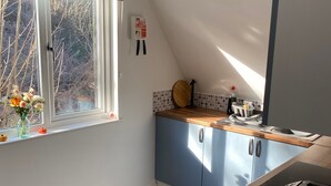 Eine Küche mit Fenster, einer Löschdecke, einem Wasserkocher und einem Toaster.