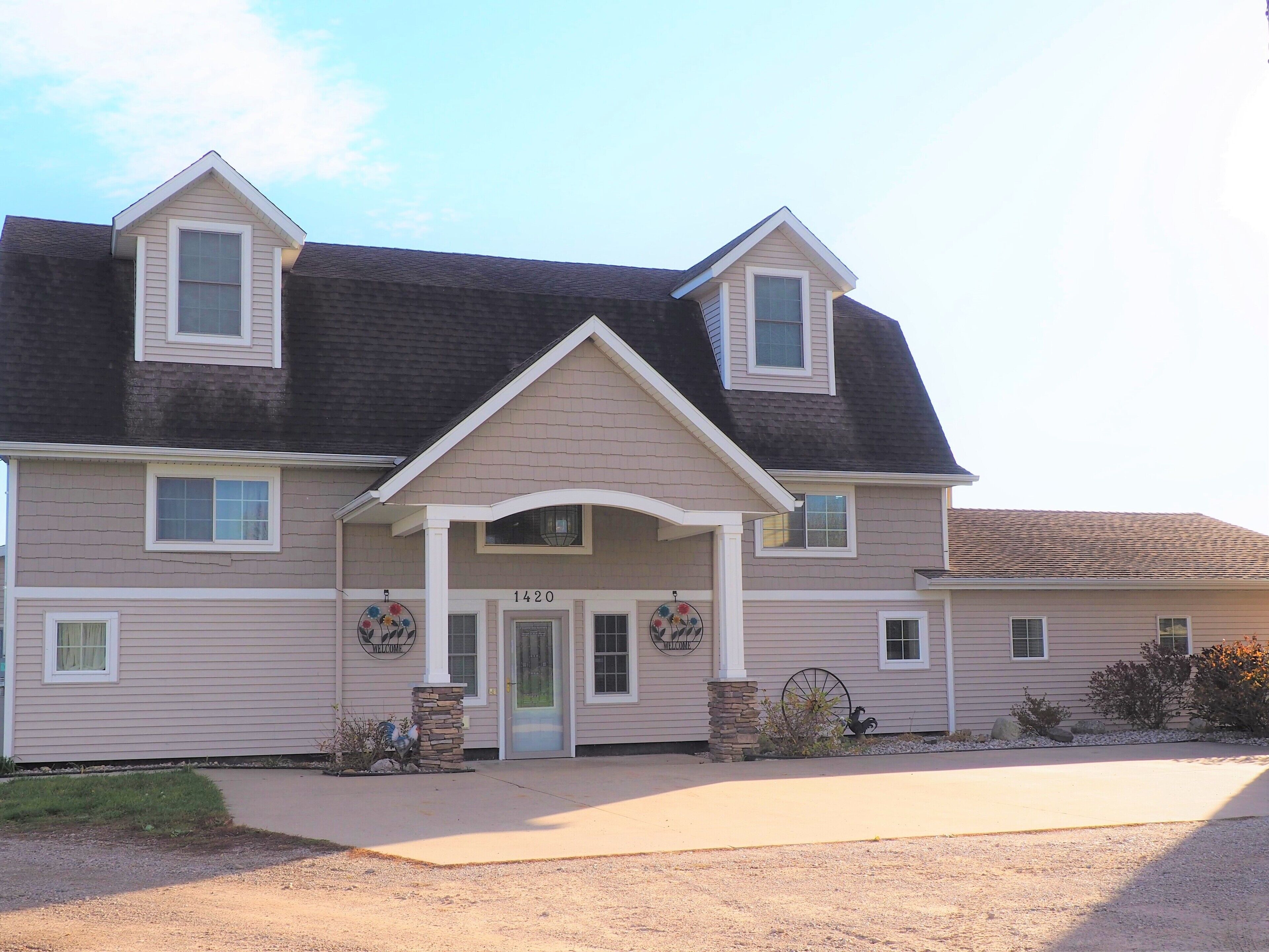 A two-story house with a front porch, a garage, and a driveway.