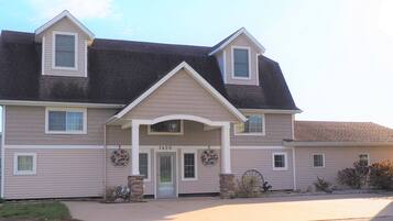 A two-story house with a front porch, a garage, and a driveway.
