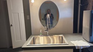 A bathroom with a sink, mirror, and overhead lights. - Riverfront house  with  kyacks  fire pit and gym (Wareham)