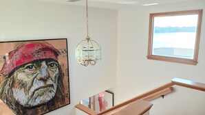 A staircase with wooden railings and a chandelier. - Riverfront house  with  kyacks  fire pit and gym (Wareham)