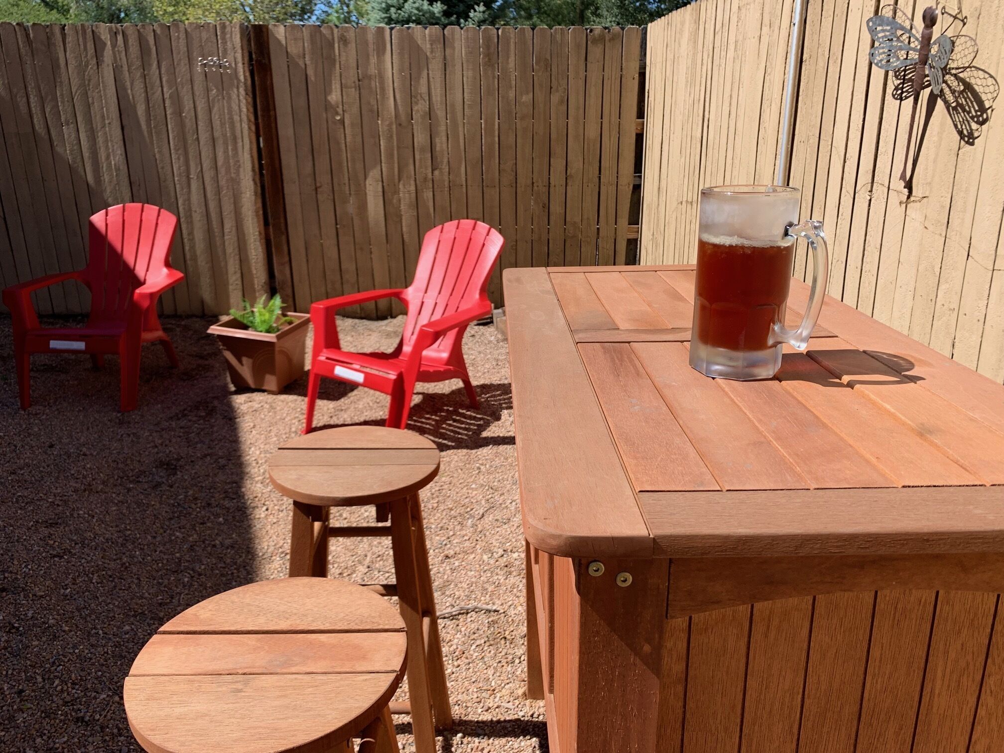 A wooden outdoor seating area with a table and two chairs.