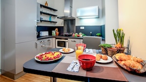 Una cocina moderna con comedor, equipada con microondas, horno y un amplio ventanal.