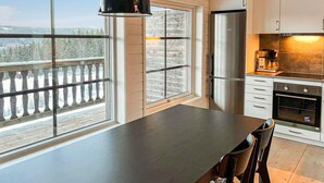 A modern kitchen with a large island, stainless steel appliances, and a view of a snowy landscape through large windows. - 4 bedroom lovely home in Sysslebäck (Sysslebäck)