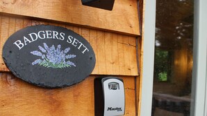Ein Holzschild mit der Aufschrift 'BADGERS SETT' und einem Master Lock.