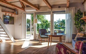 A spacious living room with a wooden ceiling, a dining area with a table and chairs, and a staircase leading to another level. - 1 bedroom cozy home in Falkenberg (Falkenberg)
