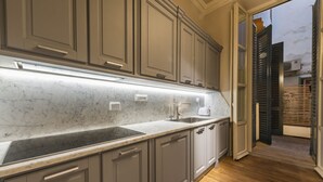 A kitchen with marble countertops, a built-in stove, and a view of the outside. - Rucellai Prestige in Florence by Mmega (Firenze)