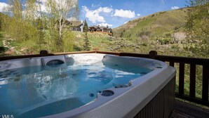 A hot tub on a wooden deck with a scenic view of a mountain and trees. - Luxe Vail! 5 minutes to town. Dual Primary - Hot Tub - Free Ski Bus! Sleeps 10 (Vail)