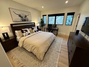A modern bedroom with a large bed, a desk, and a TV. - Luxe Vail! 5 minutes to town. Dual Primary - Hot Tub - Free Ski Bus! Sleeps 10 (Vail)