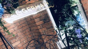 A brick wall with a metal gate and a sign reading "S. GERMAN". - Blue Piano (Birmingham)