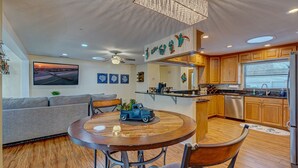 A modern kitchen with wooden cabinets, a built-in oven, and a stainless steel refrigerator. - Brian and Sarahs Hidden Gem (Merritt Island)