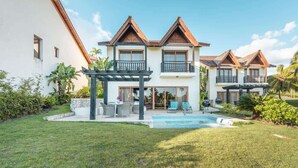 A two-story house with a swimming pool, outdoor seating, and a pergola. - Ocean View Villa with Pool & BBQ in Samana (Samaná)