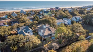 An aerial view of a coastal residential area with houses, trees, and a beach. - Cooper Cay - Marsh views, Pet friendly, Screen porch, Walk to beach & restaurants (Folly Beach)