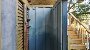 A wooden staircase leading to a dark blue door with a metal handle and a showerhead above it. - Cooper Cay - Marsh views, Pet friendly, Screen porch, Walk to beach & restaurants (Folly Beach)