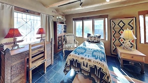 Un dormitorio con cama, cómoda, silla y mesita de noche.