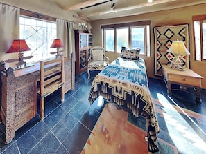 Une chambre à coucher avec un lit, une commode, une chaise et une table de chevet.