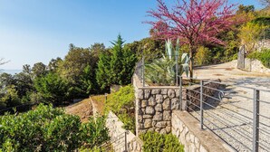 A stone staircase with metal railings leading up a hill, surrounded by lush greenery and a clear blue sky. - Beautiful apartment in Moscenicka Draga with WiFi (Moscenicka Draga)