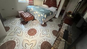 A bedroom with a bed, a bench, and a dresser. - Spacious 9 BED family sized house in a gated community (Trelawny Parish)