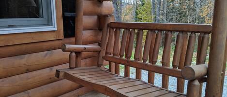 A wooden bench on a porch with a window and a star decoration.