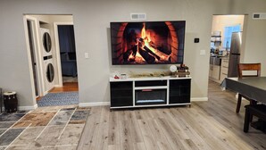 A living room with a fireplace, a television, and a dining area. - Aspen Villa-Country Club, Augustana, USF & Sanford Med. (Sioux Falls)