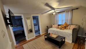 A living room with a sofa, a coffee table, a ceiling fan, and a teddy bear. - Aspen Villa-Country Club, Augustana, USF & Sanford Med. (Sioux Falls)