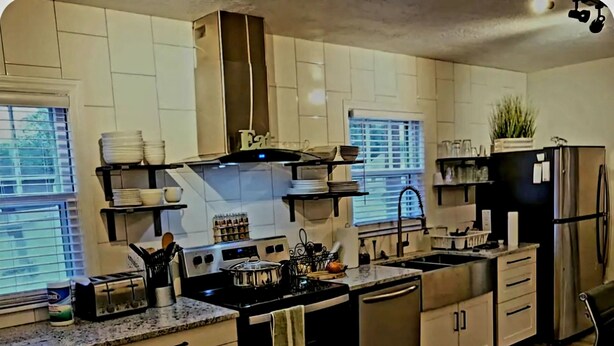 A modern kitchen with white cabinets, a stainless steel refrigerator, and a built-in oven. - Aspen Villa-Country Club, Augustana, USF & Sanford Med. (Sioux Falls)