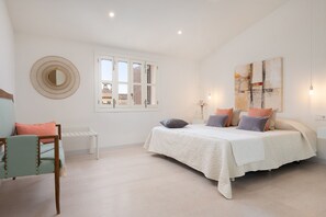 A bedroom with a bed, a chair, a round mirror, a window, and a painting on the wall. - CAN FONT (COSTITX) - Stunning villa with private pool and free WiFi. (Costitx)