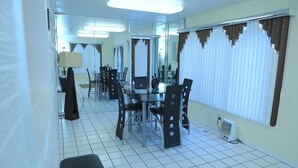 Ein Hotelzimmer mit Essbereich, der einen runden Tisch, Stühle, einen Spiegel und eine Heizung umfasst.