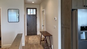 Eine moderne Küche mit Holzboden, einem eingebauten Kühlschrank und einem kleinen Holztisch.