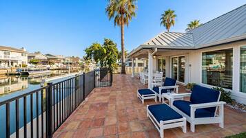 A waterfront property with a patio area featuring outdoor seating and a view of the marina.