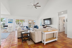 A spacious living area with a sofa, coffee table, and TV. - Flamingo House by Miss Kitty’s (Rockport)
