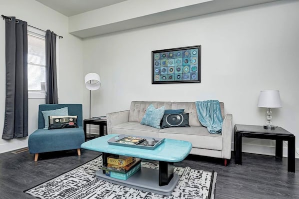 A modern living room with a sofa, a chair, a coffee table, and a framed artwork on the wall. - Located near Fountain Square - known for local music and eateries (Indianapolis)