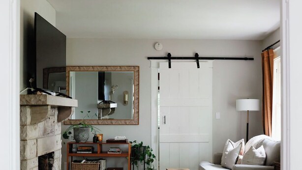 A living room with a fireplace, a sofa, a coffee table, and a TV. - The Bellmore Cottage (Nashville)