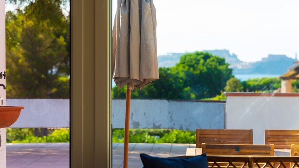 An outdoor seating area with a view of greenery and a distant landscape.