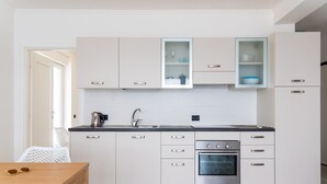 Een moderne keuken met witte kastjes, een roestvrijstalen oven en een inbouwvaatwasser.