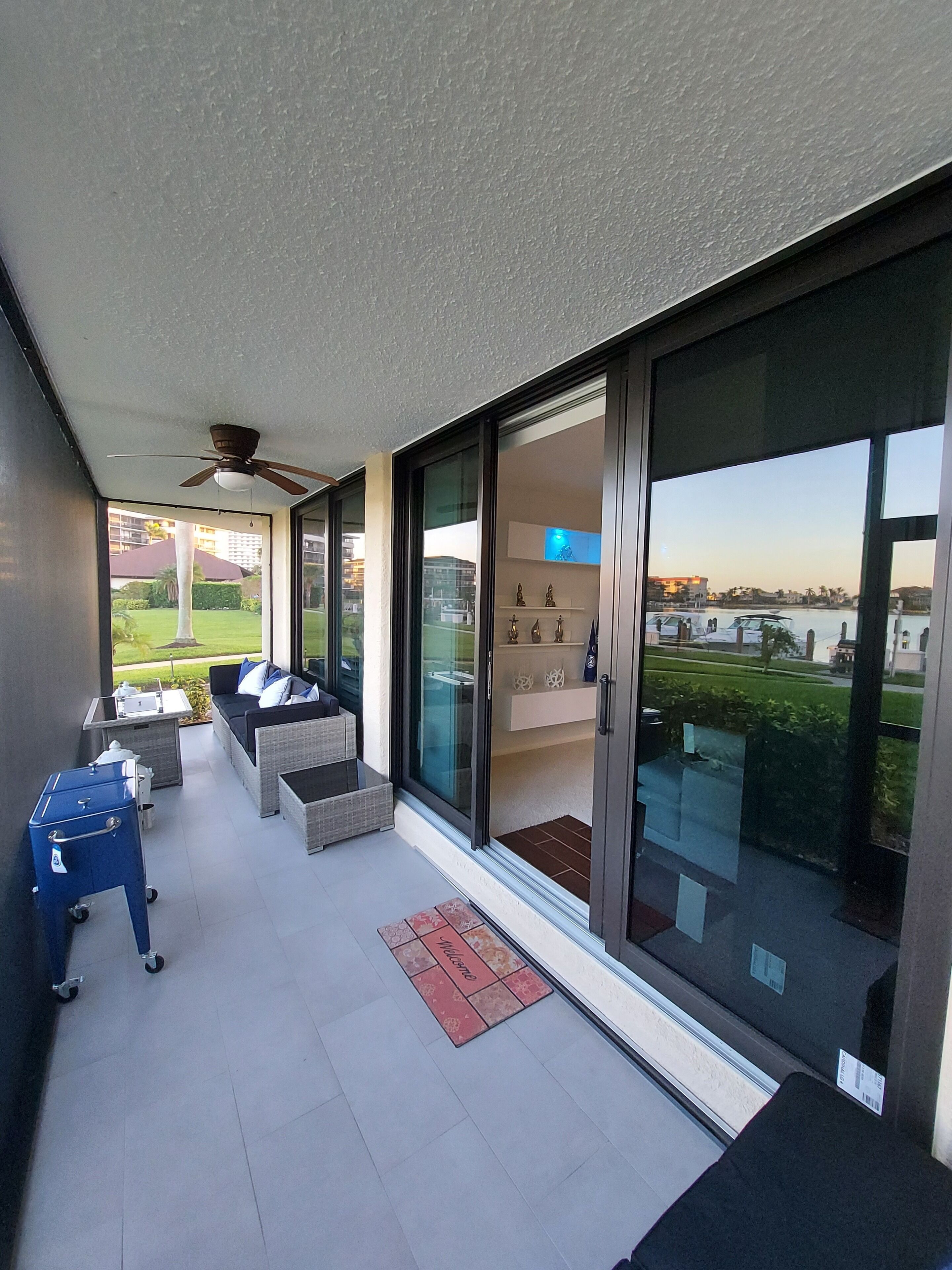 A balcony with a sofa, a small table, and a blue cart.