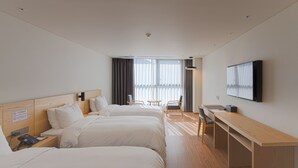 A hotel room with two beds, a desk, a chair, a TV, and a window with curtains. - Grand Moment (Busan)