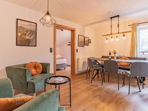 Relax in a cozy living area with a sofa, chairs, and dining table for two.