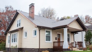 A two-story house with a front porch, a chimney, and a garage. - Cozy Cottage within walking distance of downtown! (Bristol)