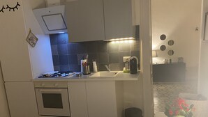 Una cocina moderna con estufa a gas, pileta y un revestimiento de pared con diseño.