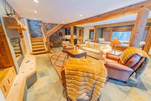 A cozy living room with a fireplace, a sofa, a chair, and a large window. - The Sunflower-Secluded luxury,hot tub,minutes to town (Skyland & Surrounding Areas)