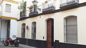 A building with a white facade, black trim, and a red motorcycle parked in front.