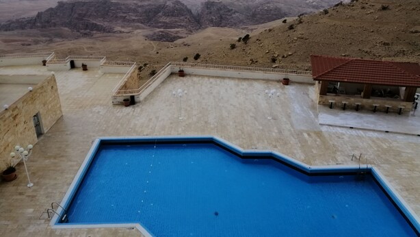 A swimming pool with a view of mountains. - Petra Panorama Hotel (Wadi Musa)