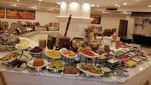 A buffet with various dishes and a large decorative centerpiece. - Petra Panorama Hotel (Wadi Musa)