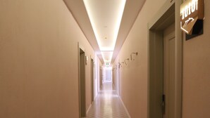 A hotel hallway with patterned floor tiles, a sign indicating room number 101, and doors on both sides. - Dolphin Park Hotel (Ortaca)