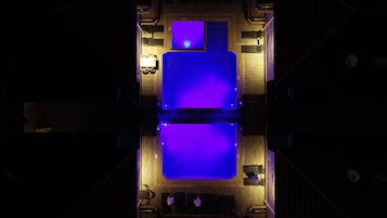 Un vestíbulo de hotel con una zona de estar central, un mostrador de recepción y una gran pantalla iluminada.