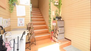 A wooden interior with a staircase, a desk with an umbrella, and a fire extinguisher. - Comfy Stay MR2 (Nara)