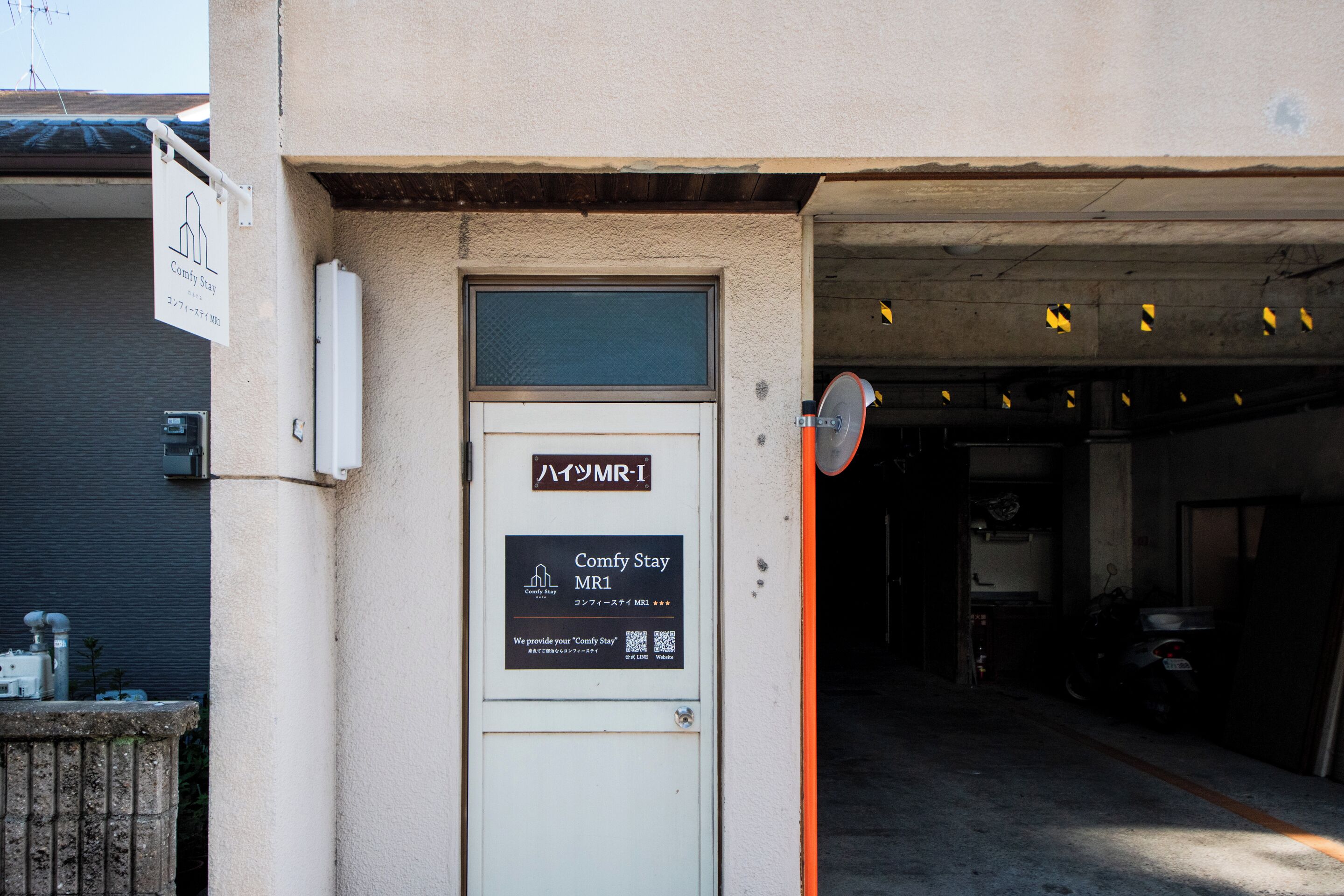 Entrada de un edificio con un cartel que dice 'Comfy Stay MR1'.